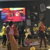 Elegant indoor event at Do it a-Ginn Event Hall featuring socializing, dancing, and sports decor with framed jerseys and memorabilia. Perfect for celebrations, parties, and gatherings.