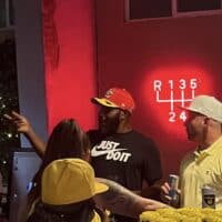 Modern event hall with vibrant red lighting, social gathering, birthday celebration, cupcake display, and sports theme decor at Do it a-Ginn Event Hall, perfect for parties and special events.