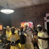 Celebrate at Do it a-Ginn Event Hall with friends at a lively gathering, featuring a rustic brick wall, ambient lighting, and a fun, social atmosphere perfect for special events and parties.